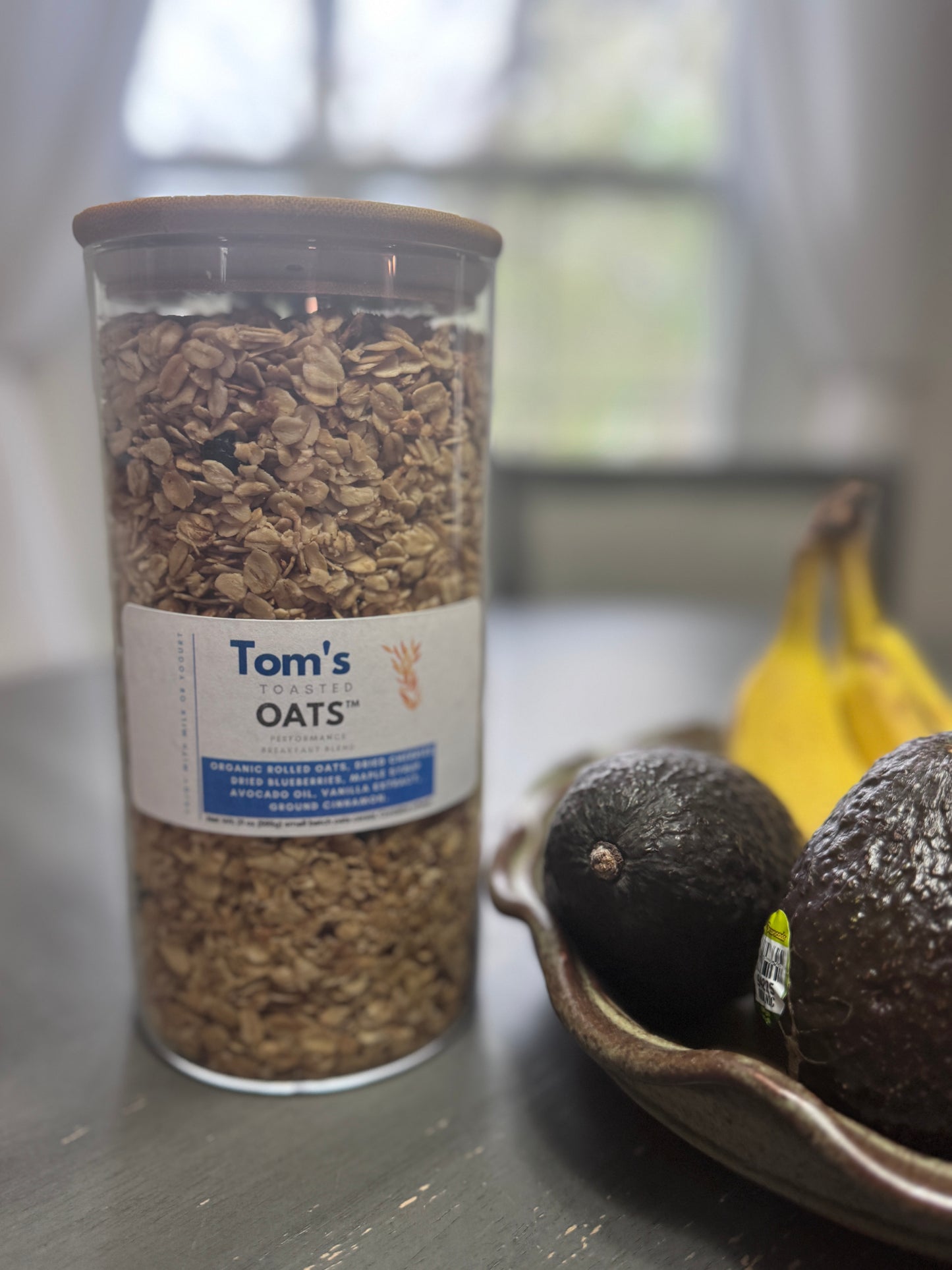 21 oz Weekend Edition Breakfast Oats. Open glass jar with bamboo lid for countertop placement.